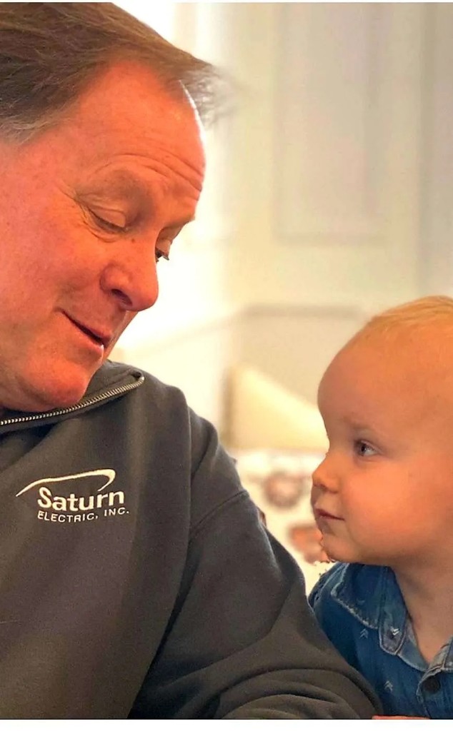 Saturn Electric team member in branded apparel with a young family member, representing decades of trusted local service